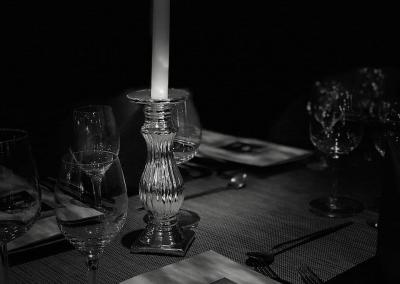 Kerze auf einer Tafel mit Weingläsern